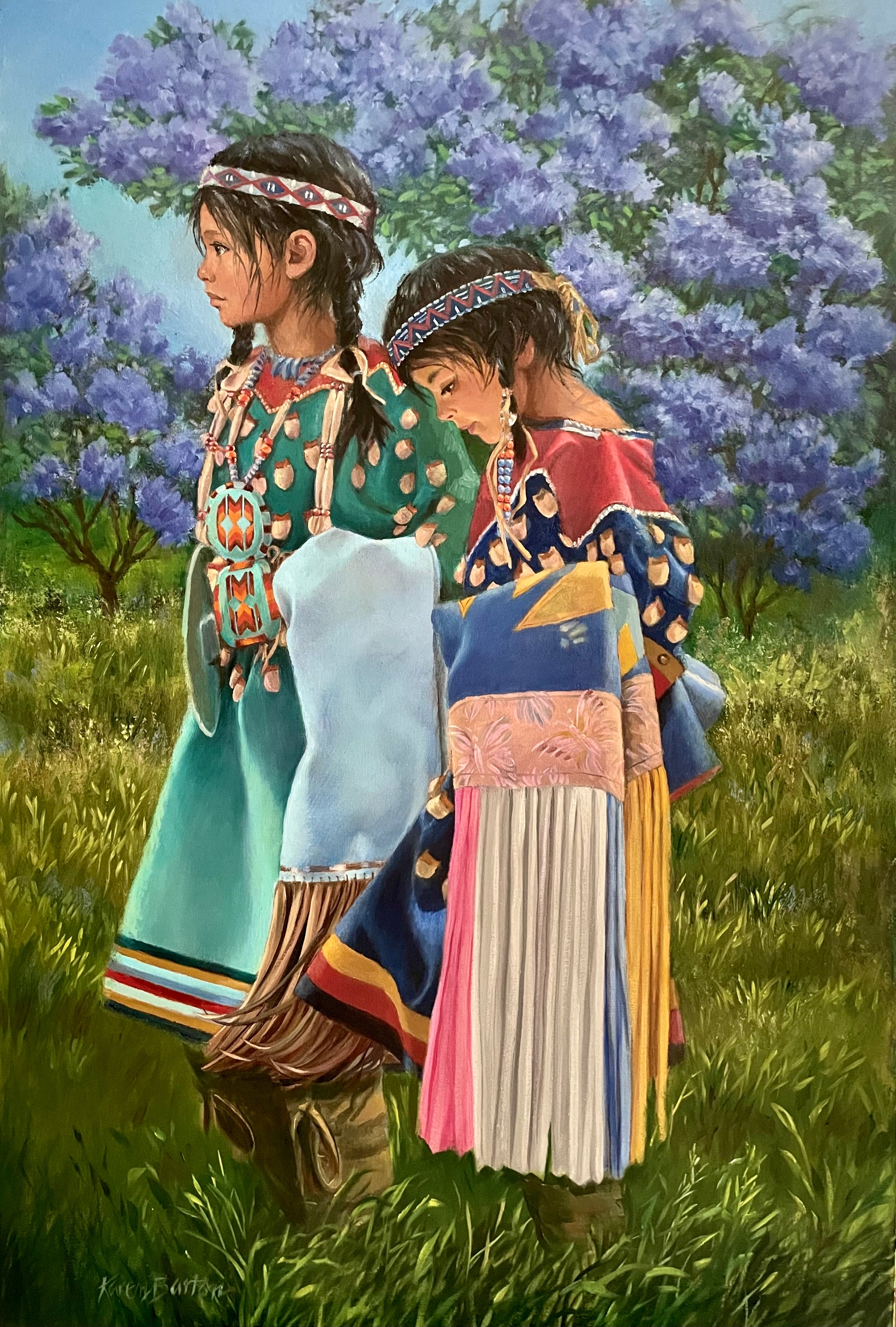 Two Indigenous women in traditional clothing standing in a field with purple flowers.